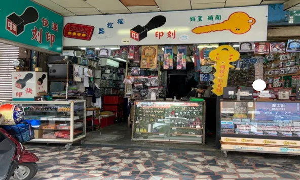 傳統街邊的鎖印店外觀，懸掛著鑰匙與遙控器招牌，象徵傳統實體鑰匙與配鎖服務的日常場景。